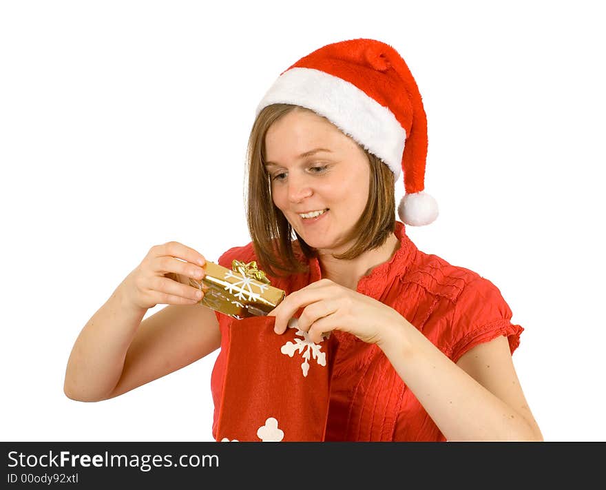 Young girl with cute smile and santa hat looking at her christmas gift in golden wrap. Young girl with cute smile and santa hat looking at her christmas gift in golden wrap