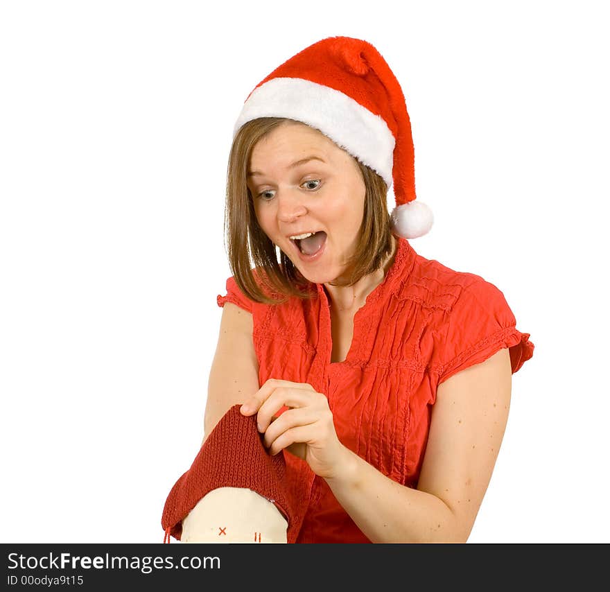 Young girl with cute smile and santa hat looking for her gift in red sock. Young girl with cute smile and santa hat looking for her gift in red sock