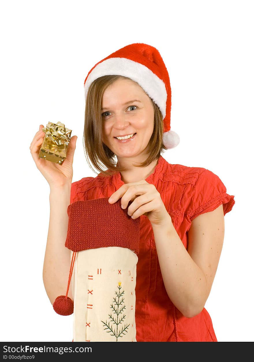 Young girl with cute smile and santa hat showing her golden gift. Young girl with cute smile and santa hat showing her golden gift