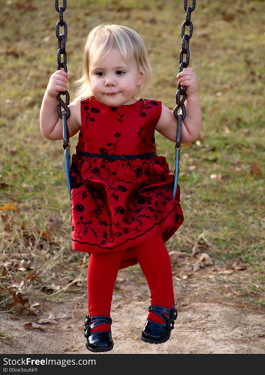 Little girl playing on swing. Little girl playing on swing.