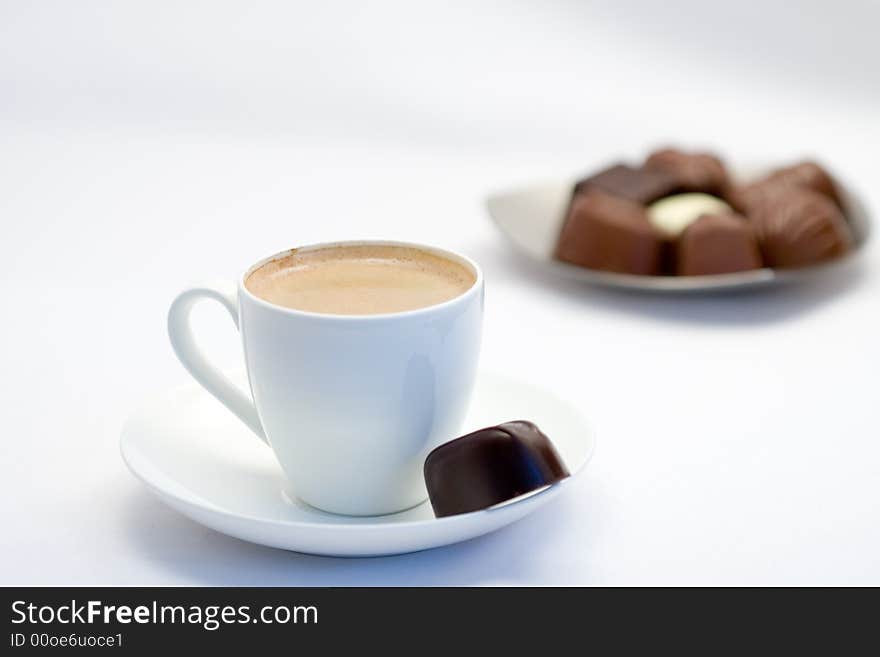 Coffee and chocolates on background