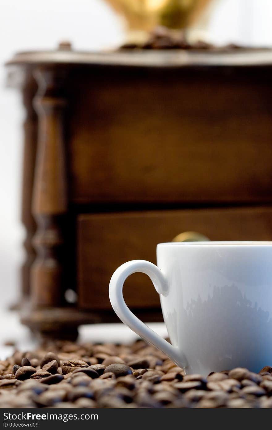 Coffee cup and a coffee grinder on a white background close-up. Coffee cup and a coffee grinder on a white background close-up