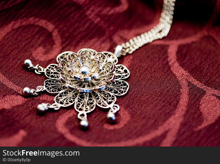 Close-up of a woman's necklace on a red surface