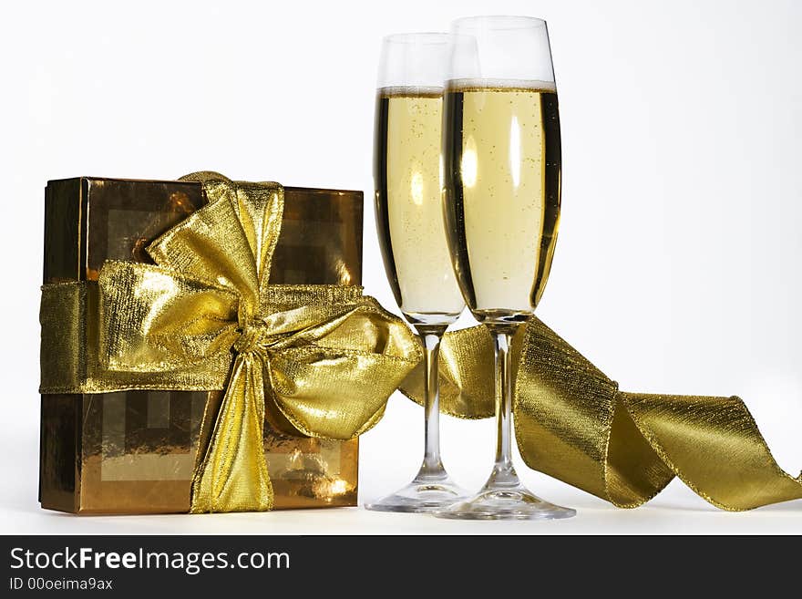 Pair of champagne flutes and golden gift box.