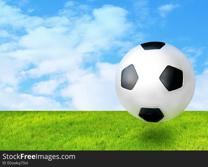 Football ball beween green grass and blue sky. Football ball beween green grass and blue sky