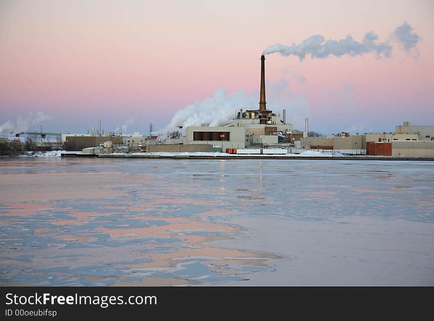Power plant located on an icy river at sunset. Power plant located on an icy river at sunset.