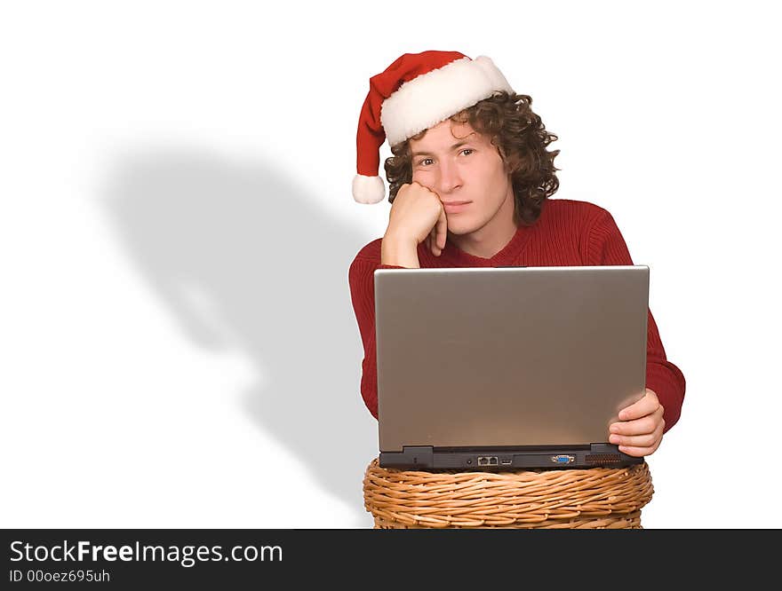 Young the man in cap Santa Claus with a computer on a white background. Young the man in cap Santa Claus with a computer on a white background