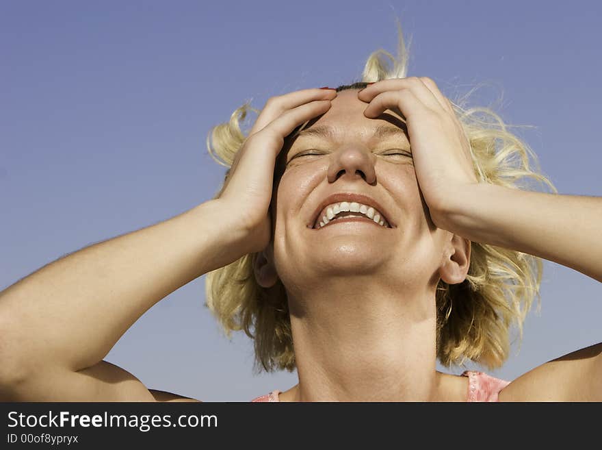 Close-up of a blonde woman outdoors laughing. Close-up of a blonde woman outdoors laughing.