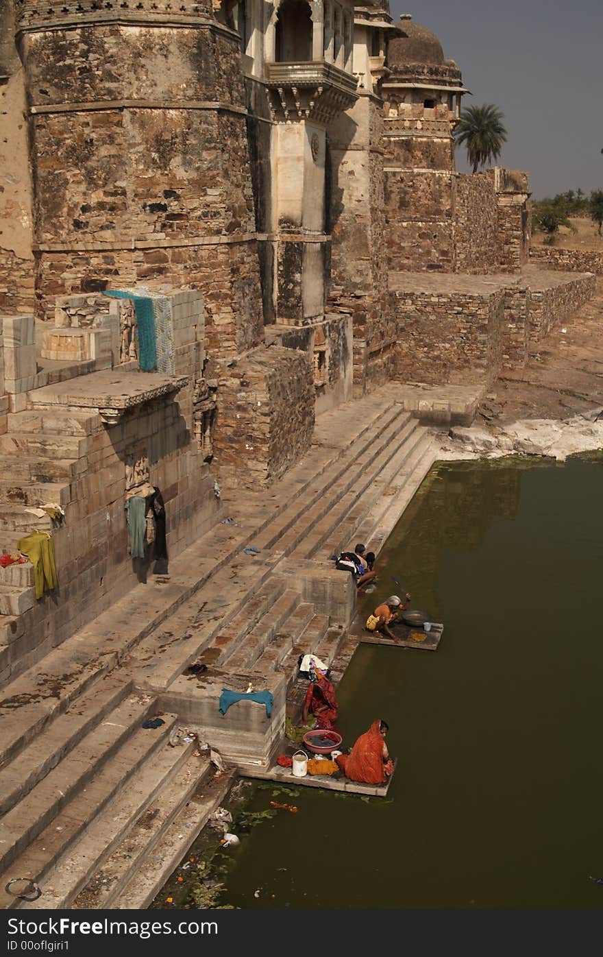 Women doing the laundry in the lake in front of Pratap Palace. Chittaugarh, Rajasthan, India. Women doing the laundry in the lake in front of Pratap Palace. Chittaugarh, Rajasthan, India.