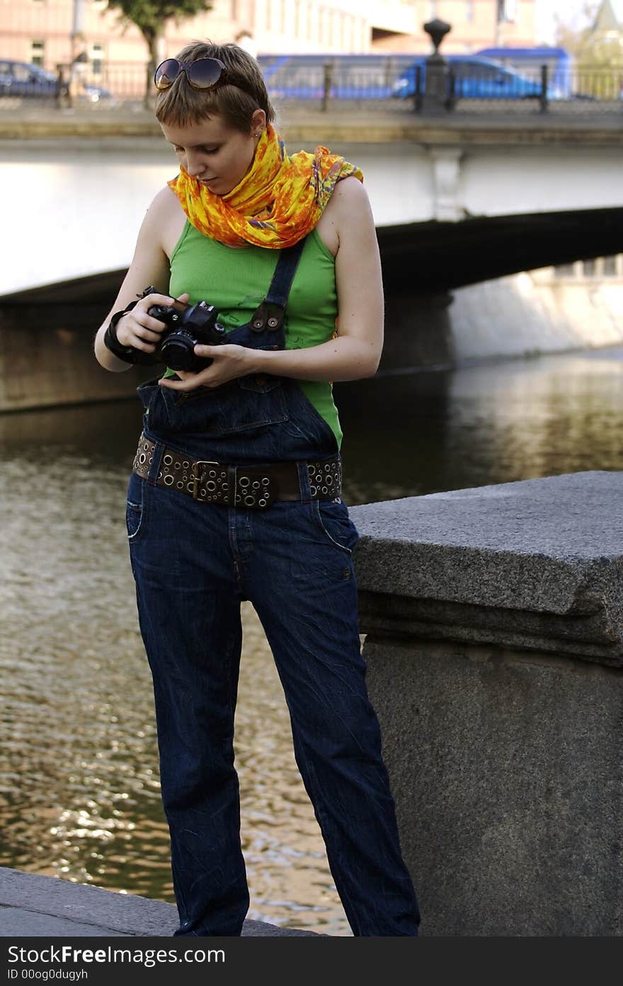 Glamour-styled girl with a camera in the citylife