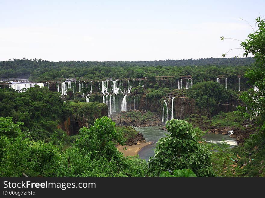 The Iguassu (or Iguazu) Falls is one of the largest masses of fresh water on the planet and divides, in South America, Brazil, Paraguay and Argentina. The waterfall system consists of 275 falls along 2.7 kilometres (1.67 miles) of the Iguazu River. Some of the individual falls are up to 82 metres (269 feet) in height, though the majority are about 64 metres (210 feet). The Iguassu (or Iguazu) Falls is one of the largest masses of fresh water on the planet and divides, in South America, Brazil, Paraguay and Argentina. The waterfall system consists of 275 falls along 2.7 kilometres (1.67 miles) of the Iguazu River. Some of the individual falls are up to 82 metres (269 feet) in height, though the majority are about 64 metres (210 feet).