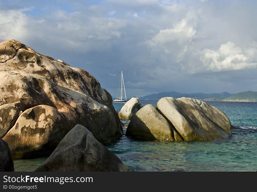 Sailboat passing the rocks at the Baths in Spanish Town on Virgin Gorda in the British Virgin Islands BVI. Sailboat passing the rocks at the Baths in Spanish Town on Virgin Gorda in the British Virgin Islands BVI