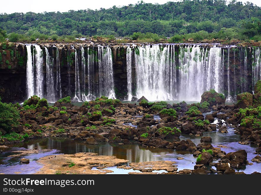 The Iguassu (or Iguazu) Falls is one of the largest masses of fresh water on the planet and divides, in South America, Brazil, Paraguay and Argentina. The waterfall system consists of 275 falls along 2.7 kilometres (1.67 miles) of the Iguazu River. Some of the individual falls are up to 82 metres (269 feet) in height, though the majority are about 64 metres (210 feet). The Iguassu (or Iguazu) Falls is one of the largest masses of fresh water on the planet and divides, in South America, Brazil, Paraguay and Argentina. The waterfall system consists of 275 falls along 2.7 kilometres (1.67 miles) of the Iguazu River. Some of the individual falls are up to 82 metres (269 feet) in height, though the majority are about 64 metres (210 feet).