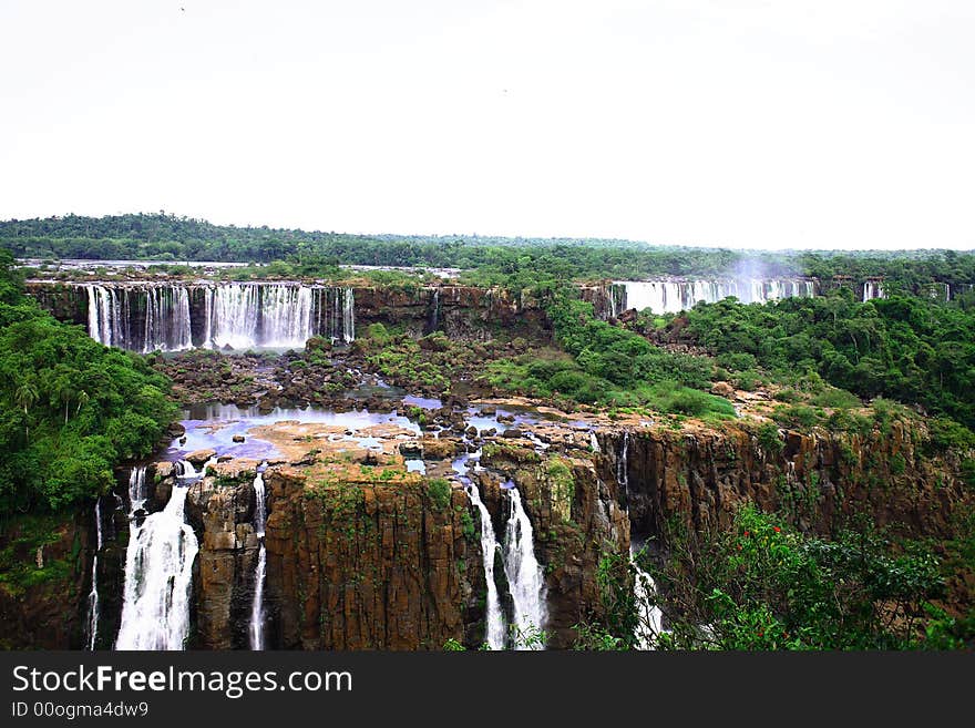 The Iguassu (or Iguazu) Falls is one of the largest masses of fresh water on the planet and divides, in South America, Brazil, Paraguay and Argentina. The waterfall system consists of 275 falls along 2.7 kilometres (1.67 miles) of the Iguazu River. Some of the individual falls are up to 82 metres (269 feet) in height, though the majority are about 64 metres (210 feet). The Iguassu (or Iguazu) Falls is one of the largest masses of fresh water on the planet and divides, in South America, Brazil, Paraguay and Argentina. The waterfall system consists of 275 falls along 2.7 kilometres (1.67 miles) of the Iguazu River. Some of the individual falls are up to 82 metres (269 feet) in height, though the majority are about 64 metres (210 feet).