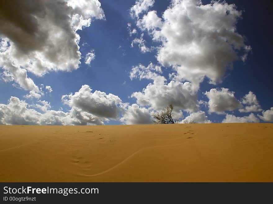 Deserted landscape against the blue sky with expressive clouds. Deserted landscape against the blue sky with expressive clouds