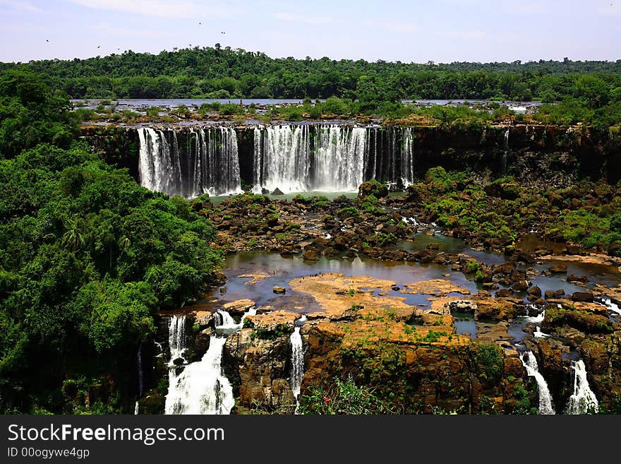 The Iguassu (or Iguazu) Falls is one of the largest masses of fresh water on the planet and divides, in South America, Brazil, Paraguay and Argentina. The waterfall system consists of 275 falls along 2.7 kilometres (1.67 miles) of the Iguazu River. Some of the individual falls are up to 82 metres (269 feet) in height, though the majority are about 64 metres (210 feet). The Iguassu (or Iguazu) Falls is one of the largest masses of fresh water on the planet and divides, in South America, Brazil, Paraguay and Argentina. The waterfall system consists of 275 falls along 2.7 kilometres (1.67 miles) of the Iguazu River. Some of the individual falls are up to 82 metres (269 feet) in height, though the majority are about 64 metres (210 feet).