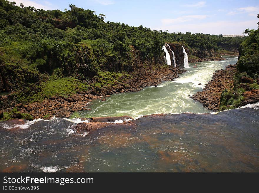 The Iguassu (or Iguazu) Falls is one of the largest masses of fresh water on the planet and divides, in South America, Brazil, Paraguay and Argentina. The waterfall system consists of 275 falls along 2.7 kilometres (1.67 miles) of the Iguazu River. Some of the individual falls are up to 82 metres (269 feet) in height, though the majority are about 64 metres (210 feet). The Iguassu (or Iguazu) Falls is one of the largest masses of fresh water on the planet and divides, in South America, Brazil, Paraguay and Argentina. The waterfall system consists of 275 falls along 2.7 kilometres (1.67 miles) of the Iguazu River. Some of the individual falls are up to 82 metres (269 feet) in height, though the majority are about 64 metres (210 feet).