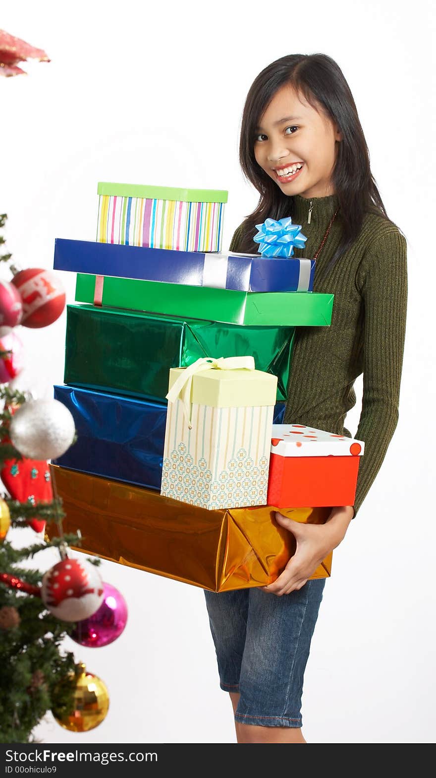 A cheerful girl holding a bunch of christmas gift