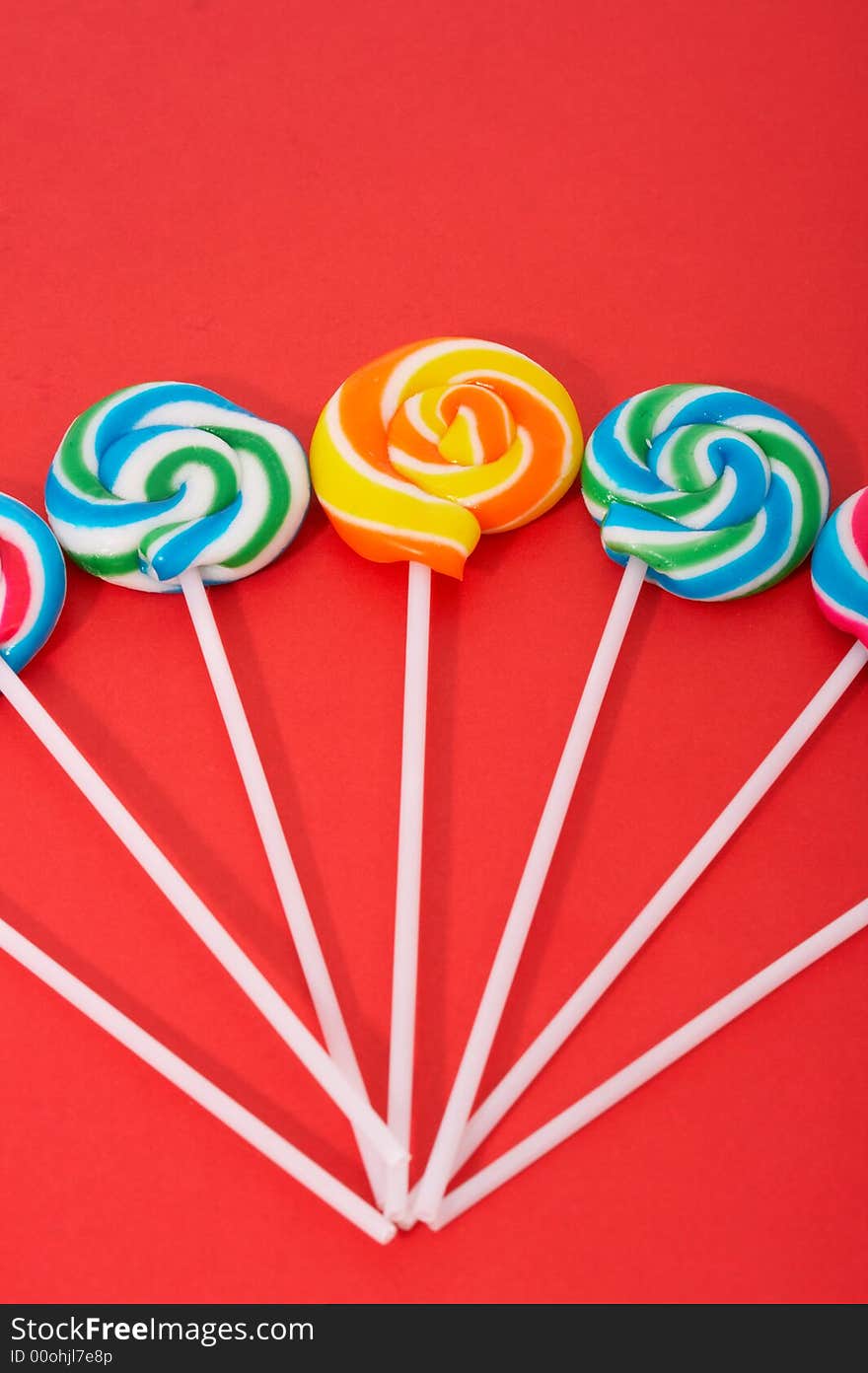 Twirl lollipop candies over a red background