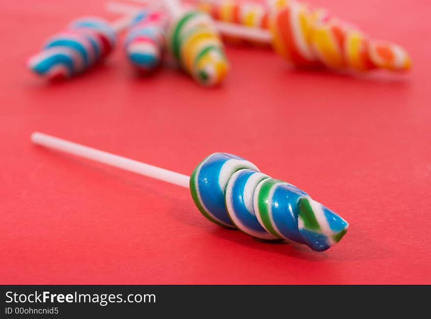 Twirl lollipop candies over a red background