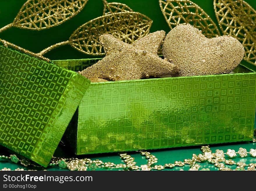 Green gift box and golden celebration leaves