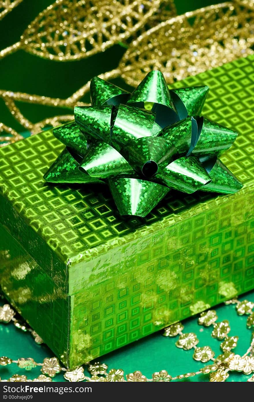 Green gift box and golden celebration leaves