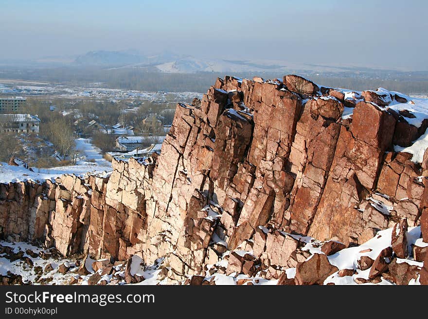 Steep rock in the winter. Village