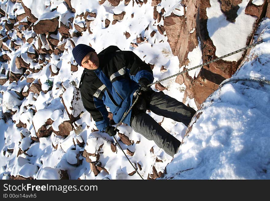 Rock-climber on rock and snow