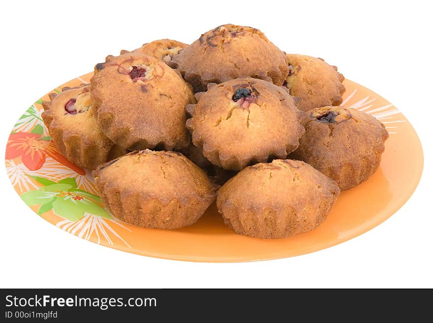 Tasty small baked cakes filled with cherry and raisins on orange round plate isolated on white. Tasty small baked cakes filled with cherry and raisins on orange round plate isolated on white