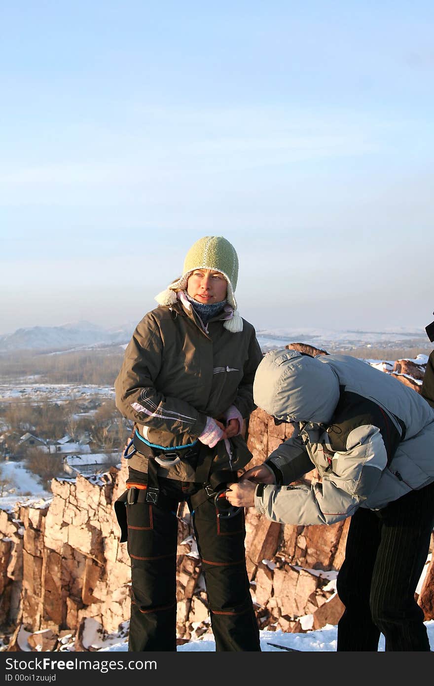 Girl rock-climber on rock in winter