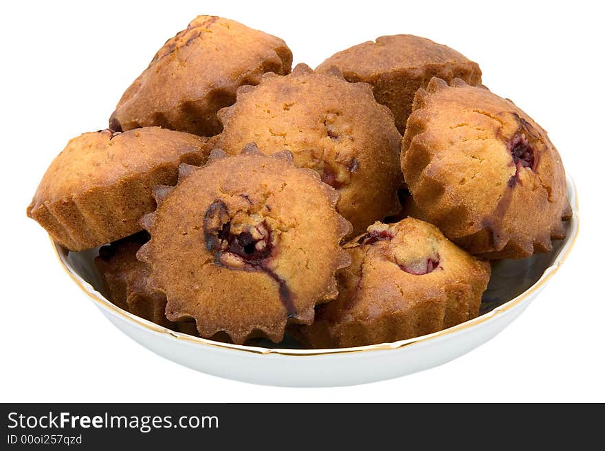 Tasty small baked cakes filled with cherry and raisins in white round bowl isolated on white. Tasty small baked cakes filled with cherry and raisins in white round bowl isolated on white