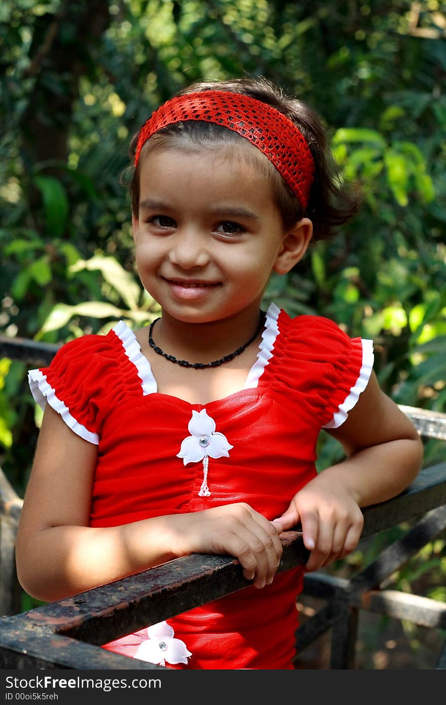 A small girl dressed in red smiling happily. A small girl dressed in red smiling happily.