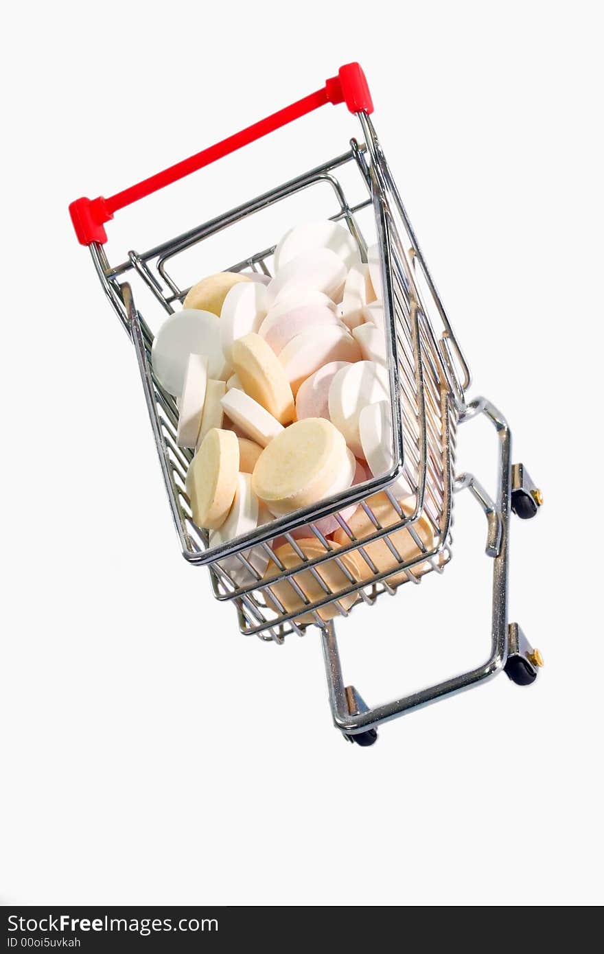 Vitamin pills in a model trolley on bright background. Vitamin pills in a model trolley on bright background