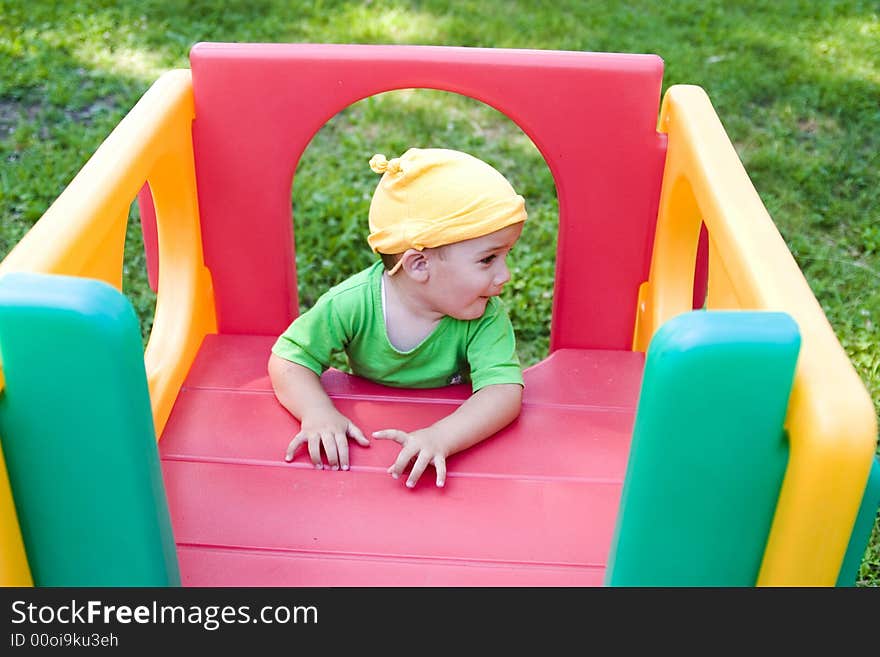 A cute little caucasian boy with happy smiling facial expression playing on a jungle gym in the backyard outdoors. A cute little caucasian boy with happy smiling facial expression playing on a jungle gym in the backyard outdoors