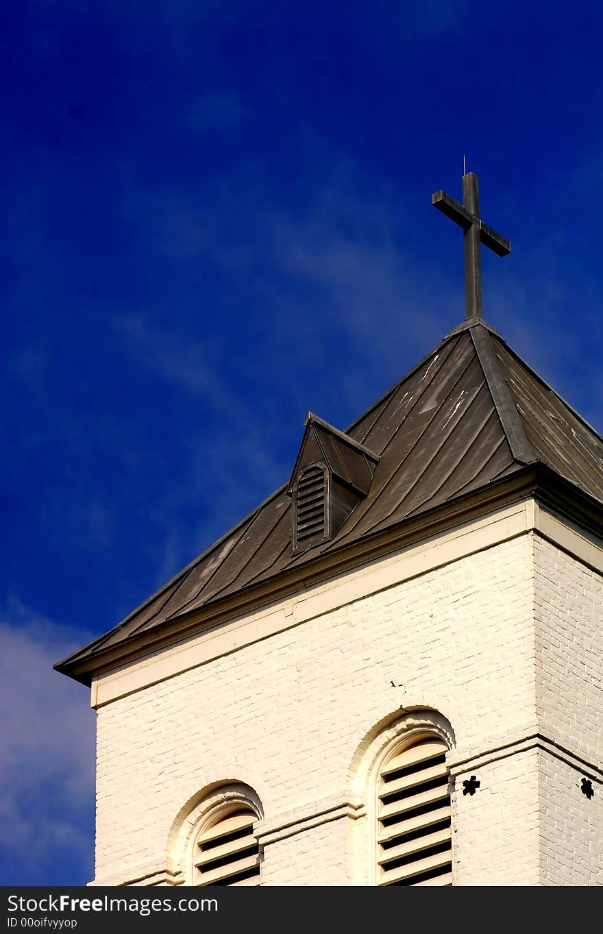 Lone church against perfect blue sky with cross