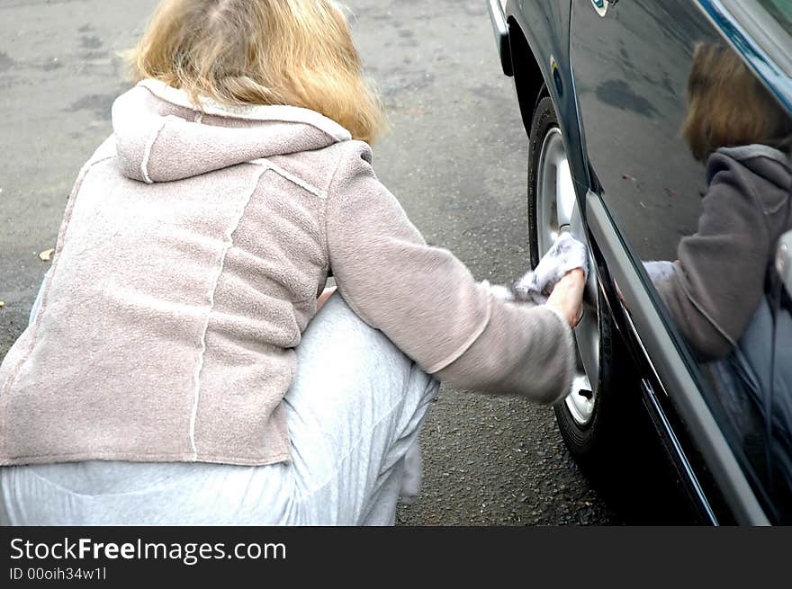 Woman cleaning her car at a carwash.