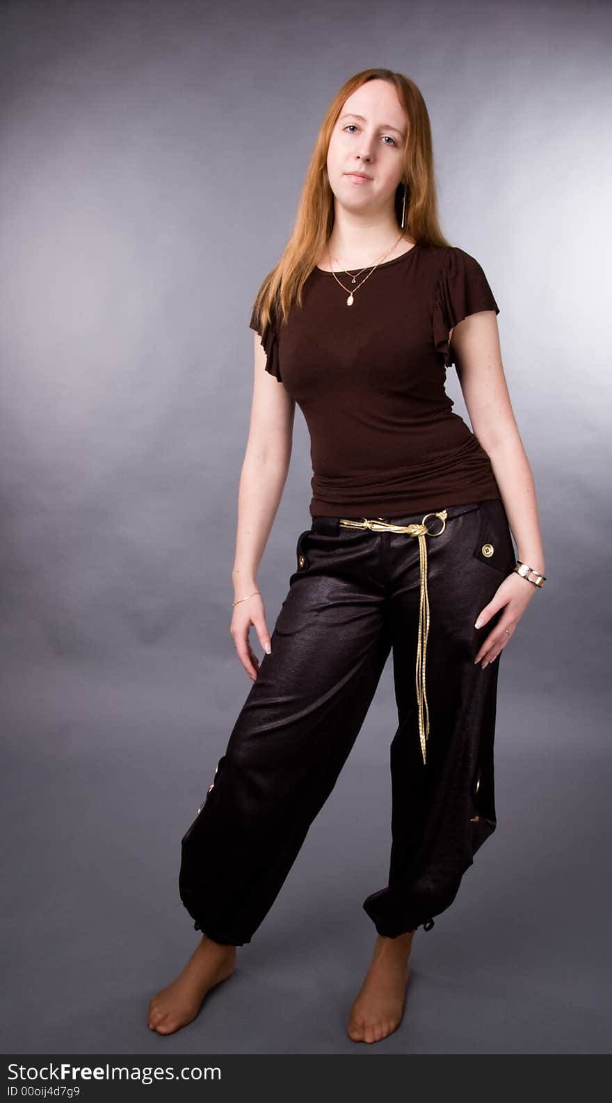 The young girl in brown shirt-blouse on a grey background