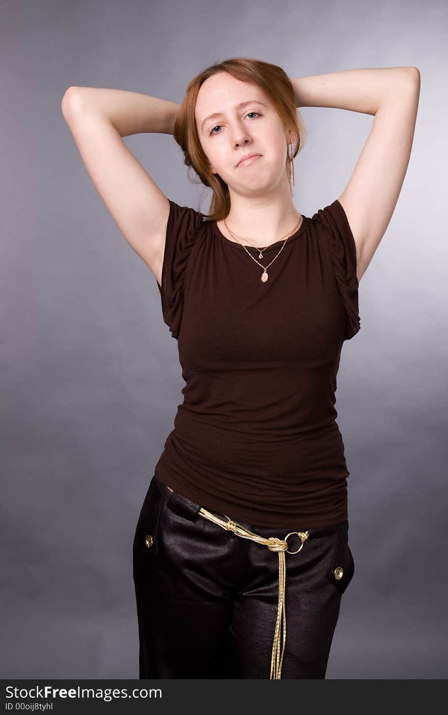 The young girl in brown shirt-blouse on a grey background