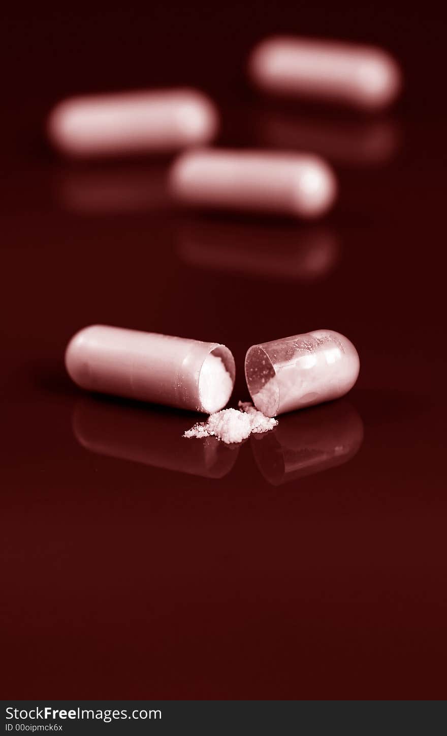 Close up of pill spilling white powder on red background. Close up of pill spilling white powder on red background