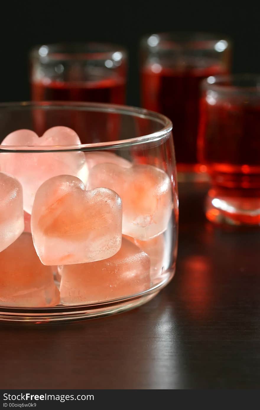 A bowl of pink heart shaped ice cubes and cocktails