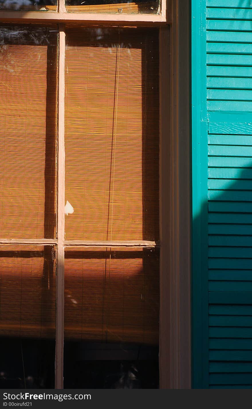 Image of a green shuuter on exterior of southern home. Image of a green shuuter on exterior of southern home