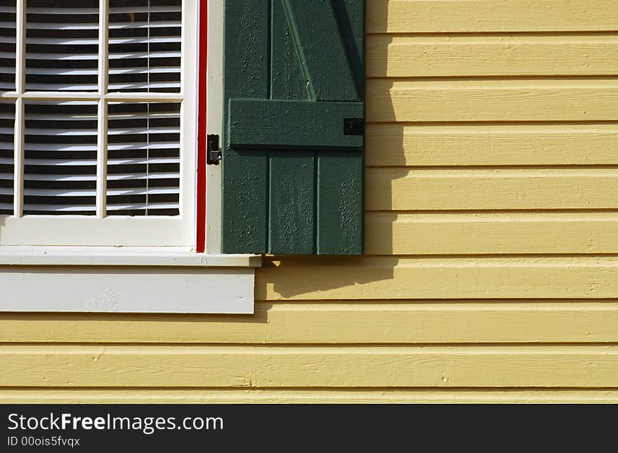 Image of a pretty gold house with a green shutter. Image of a pretty gold house with a green shutter