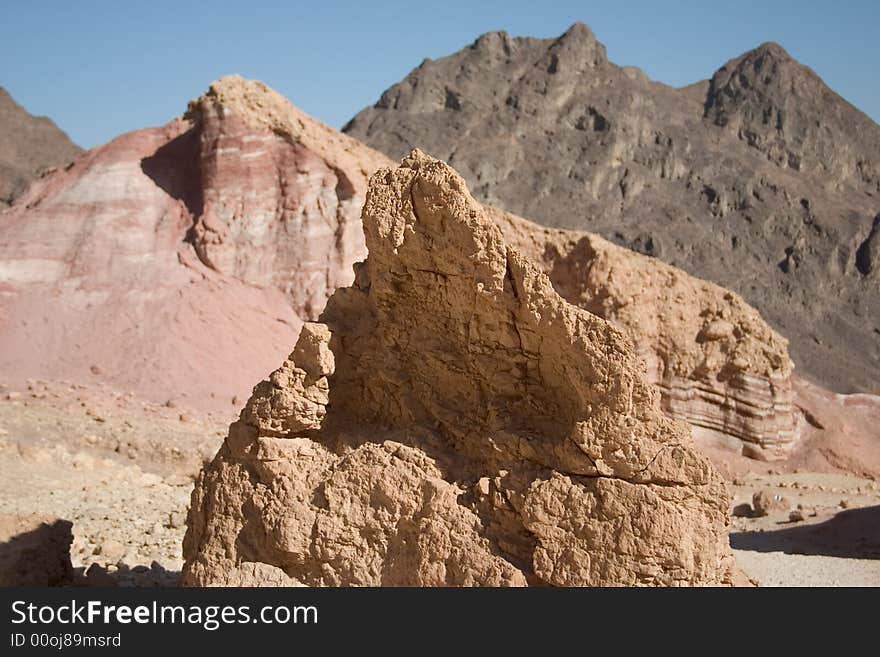 A rock in Negev desert with mountains in the background. A rock in Negev desert with mountains in the background.