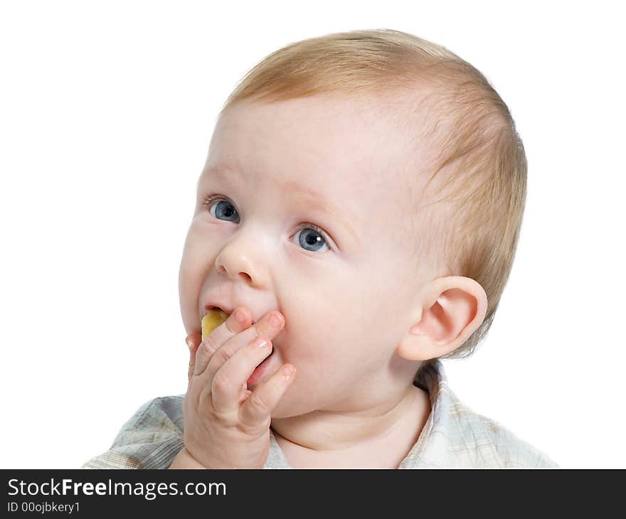 12-month old blue eyed toddler eating a piece of banana. 12-month old blue eyed toddler eating a piece of banana