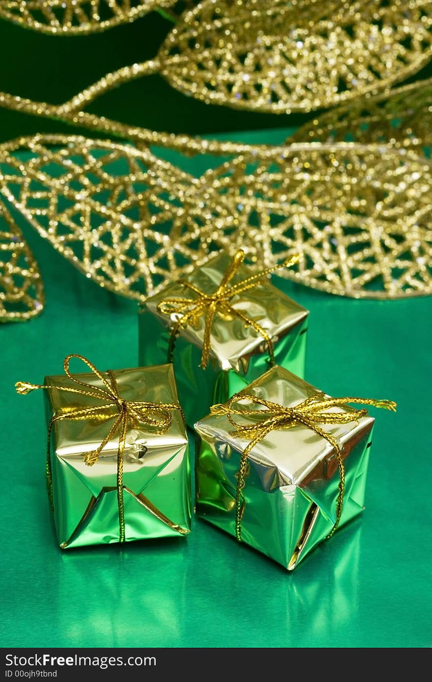 Golden gift boxes on green background with leaf