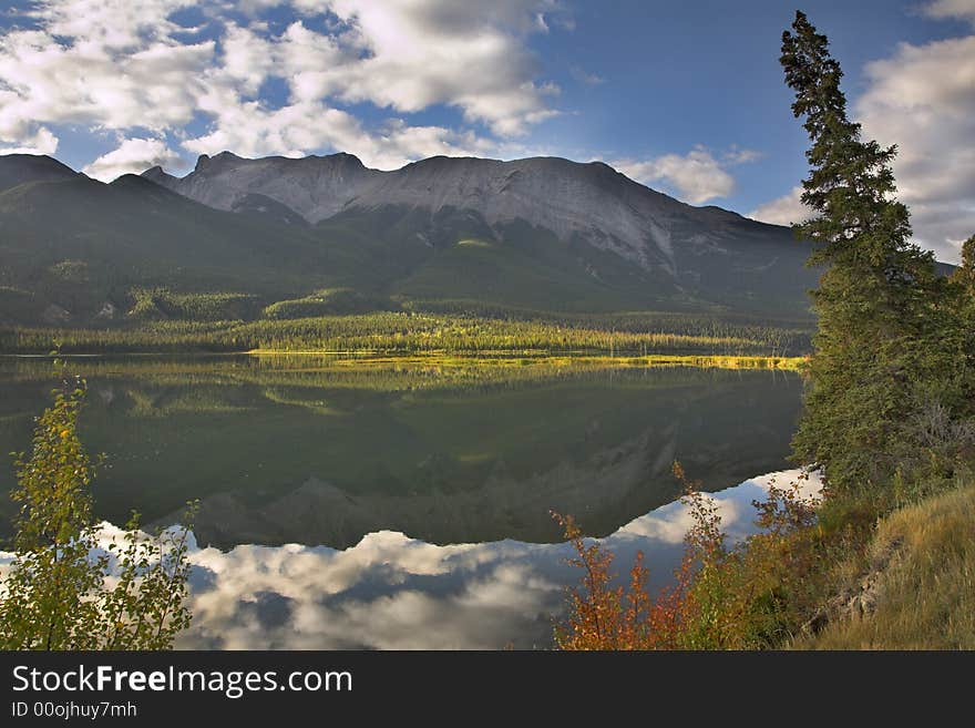 Mountain lake the reflecting sky and mountains in the cold morning. Mountain lake the reflecting sky and mountains in the cold morning