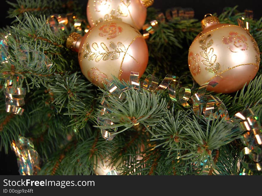 Pearly gold ornaments  and ribbon on a pine bough reflected in a mirror. Pearly gold ornaments  and ribbon on a pine bough reflected in a mirror.