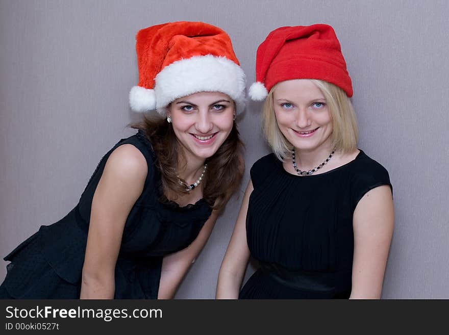 Two beautiful girls are in red christmas caps