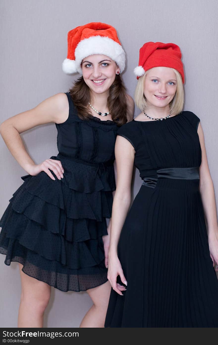 Two beautiful girls are in red christmas caps