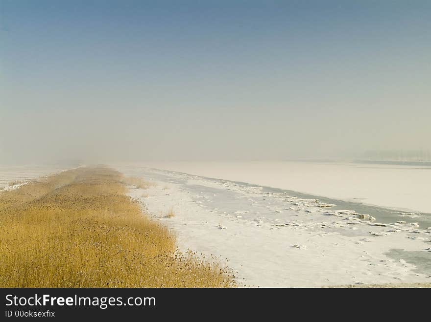 The blocks of ice in the river are flowing.
The reed by bank looks languished. The blocks of ice in the river are flowing.
The reed by bank looks languished.